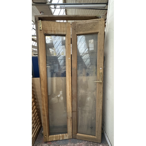 54 - A pair of wooden glazed conservatory doors with frame - approx. 236cm high x 122cm wide including fr... 