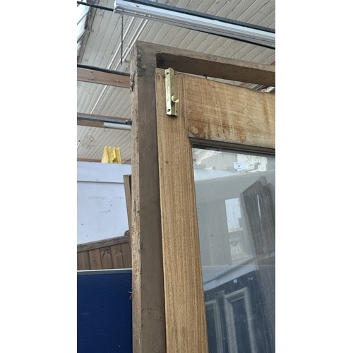 54 - A pair of wooden glazed conservatory doors with frame - approx. 236cm high x 122cm wide including fr... 