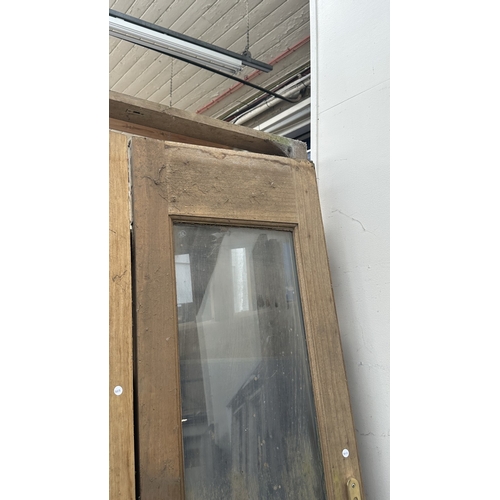 54 - A pair of wooden glazed conservatory doors with frame - approx. 236cm high x 122cm wide including fr... 