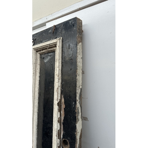 56 - A Victorian black and white painted wooden four panel door - approx. 195cm high x 81cm wide