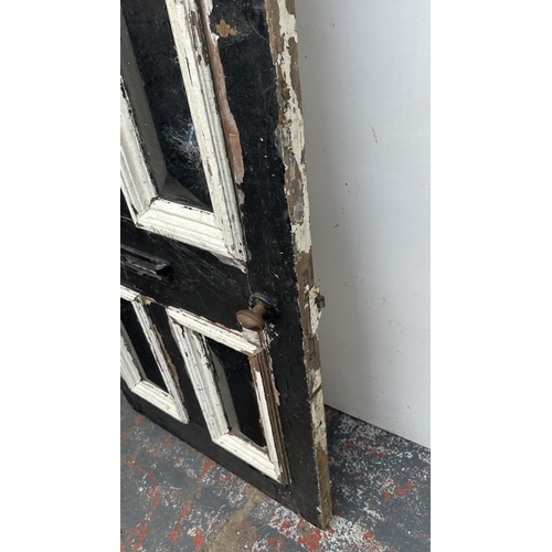 56 - A Victorian black and white painted wooden four panel door - approx. 195cm high x 81cm wide