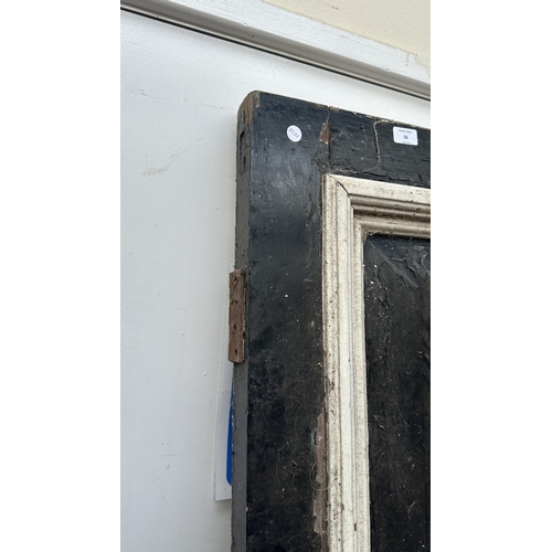 56 - A Victorian black and white painted wooden four panel door - approx. 195cm high x 81cm wide