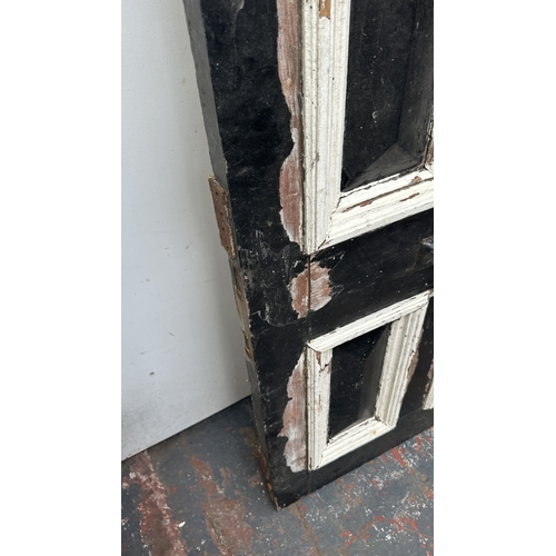 56 - A Victorian black and white painted wooden four panel door - approx. 195cm high x 81cm wide