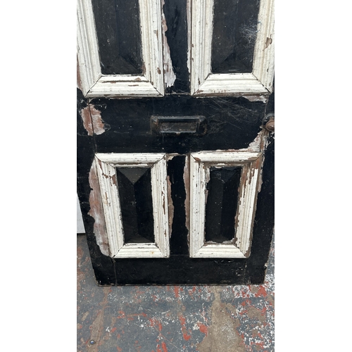 56 - A Victorian black and white painted wooden four panel door - approx. 195cm high x 81cm wide