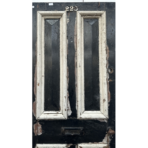 56 - A Victorian black and white painted wooden four panel door - approx. 195cm high x 81cm wide