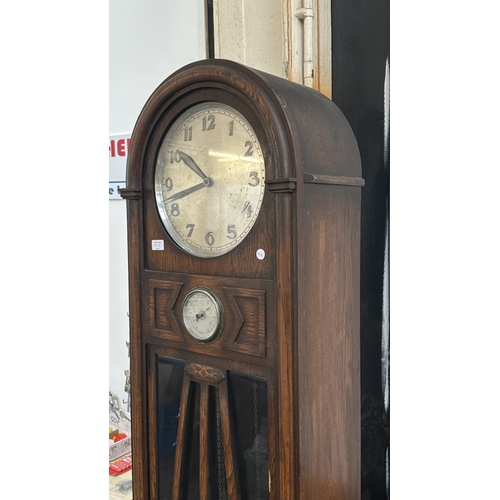 63A - An Art Deco oak cased grandfather clock with fitted British made aneroid barometer, pendulum and thr... 