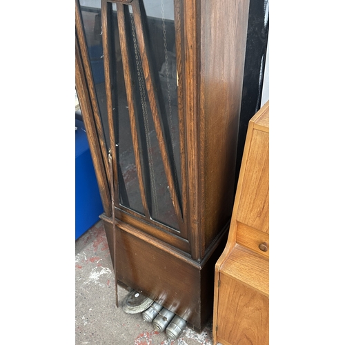 63A - An Art Deco oak cased grandfather clock with fitted British made aneroid barometer, pendulum and thr... 