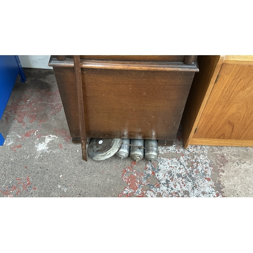 63A - An Art Deco oak cased grandfather clock with fitted British made aneroid barometer, pendulum and thr... 