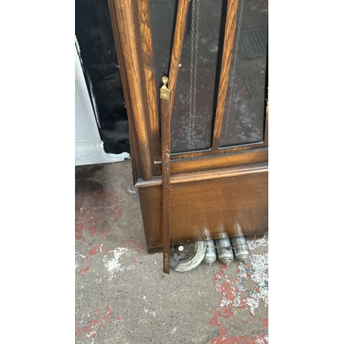 63A - An Art Deco oak cased grandfather clock with fitted British made aneroid barometer, pendulum and thr... 