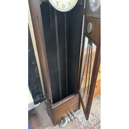 63A - An Art Deco oak cased grandfather clock with fitted British made aneroid barometer, pendulum and thr... 