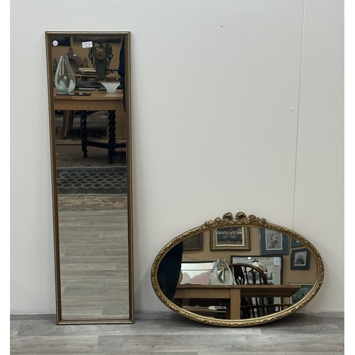 63E - Two gilt framed wall mirrors, one oval - approx. 49cm high x 71cm wide and one rectangular - approx.... 