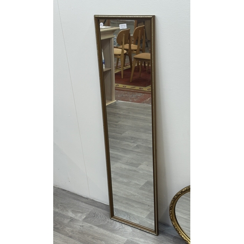 63E - Two gilt framed wall mirrors, one oval - approx. 49cm high x 71cm wide and one rectangular - approx.... 