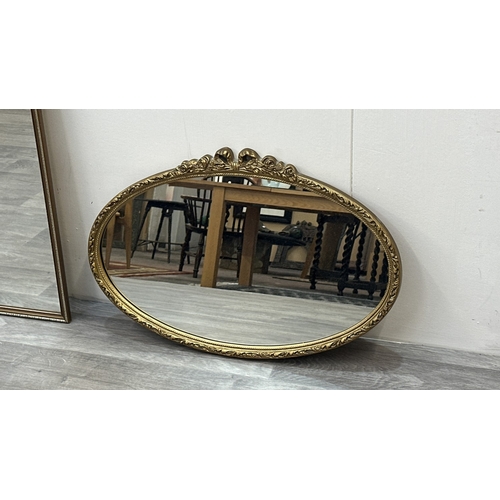 63E - Two gilt framed wall mirrors, one oval - approx. 49cm high x 71cm wide and one rectangular - approx.... 