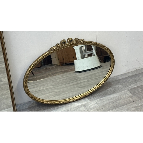 63E - Two gilt framed wall mirrors, one oval - approx. 49cm high x 71cm wide and one rectangular - approx.... 