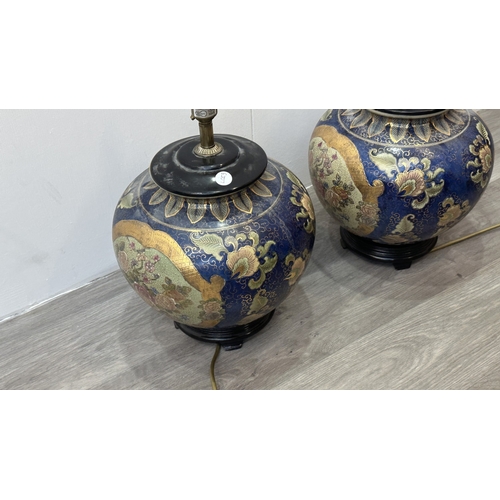 81 - A pair of Oriental hand decorated ceramic ginger jar table lamps on wooden plinths - approx. 37cm hi... 