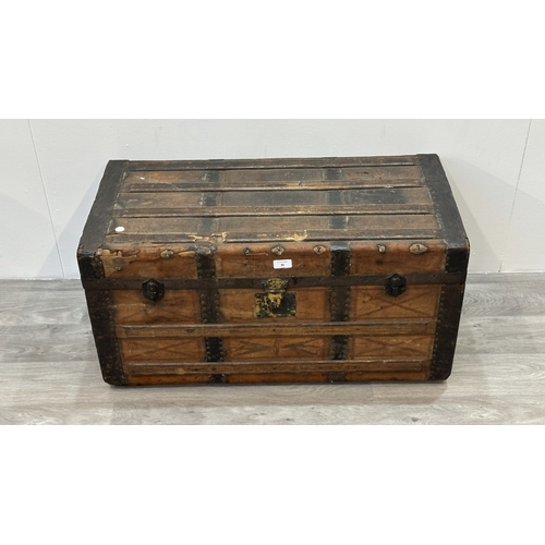 86 - A late 19th/early 20th century brown leather covered steamer trunk with wooden banding, metal decora... 