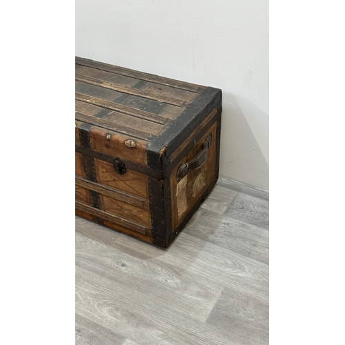 86 - A late 19th/early 20th century brown leather covered steamer trunk with wooden banding, metal decora... 