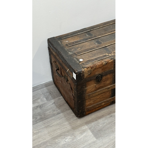 86 - A late 19th/early 20th century brown leather covered steamer trunk with wooden banding, metal decora... 
