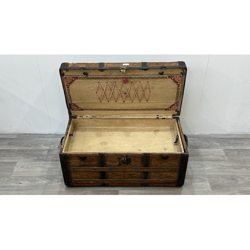 86 - A late 19th/early 20th century brown leather covered steamer trunk with wooden banding, metal decora... 