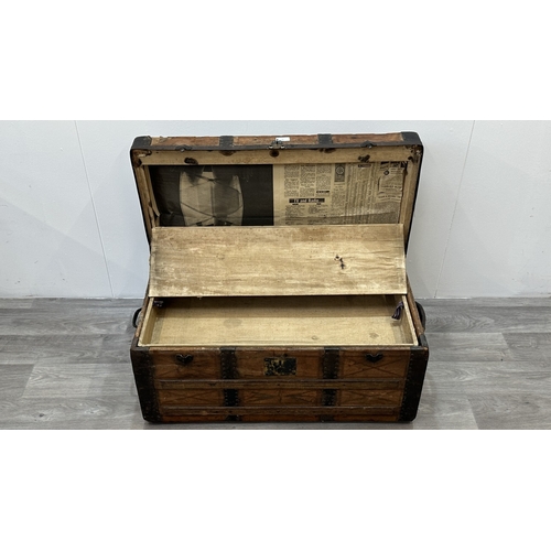 86 - A late 19th/early 20th century brown leather covered steamer trunk with wooden banding, metal decora... 