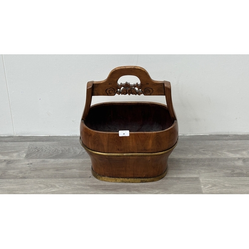 88 - A Chinese carved elm and gilt metal water bucket - approx. 45cm high x 38cm wide x 26cm deep