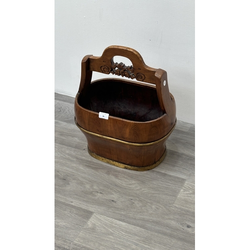 88 - A Chinese carved elm and gilt metal water bucket - approx. 45cm high x 38cm wide x 26cm deep