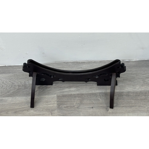 89 - A Chinese celadon glazed ceramic charger with dragon motif on carved wooden stand - approx. 50cm dia... 