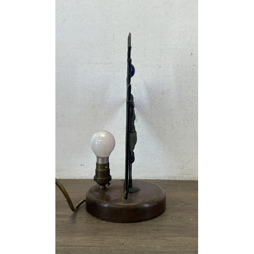 92 - An Art Deco style Tiffany type stained glass table lamp with cast metal flapper girl design on woode... 