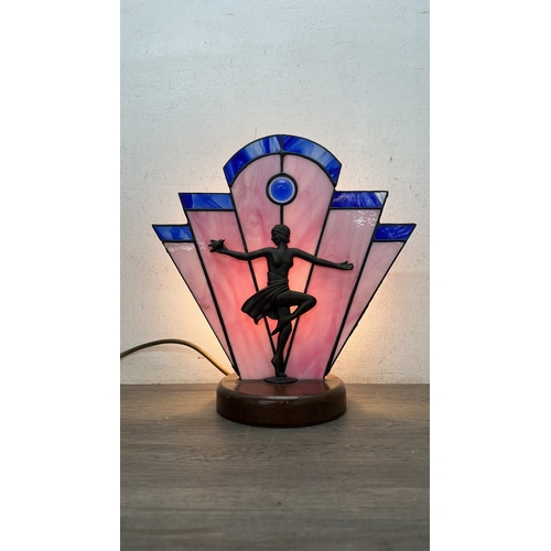 92 - An Art Deco style Tiffany type stained glass table lamp with cast metal flapper girl design on woode... 