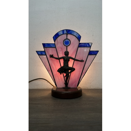 92 - An Art Deco style Tiffany type stained glass table lamp with cast metal flapper girl design on woode... 