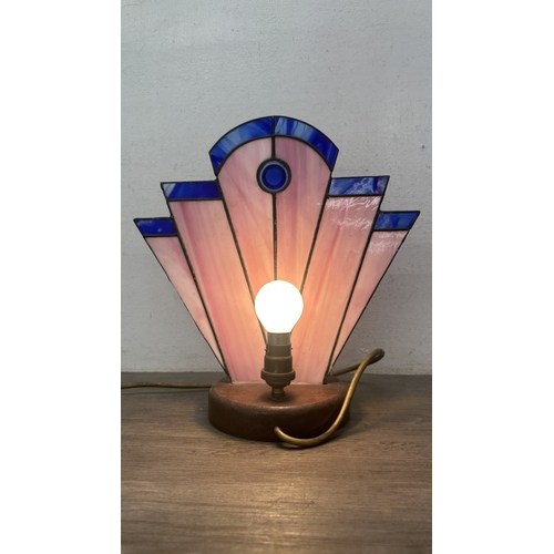 92 - An Art Deco style Tiffany type stained glass table lamp with cast metal flapper girl design on woode... 