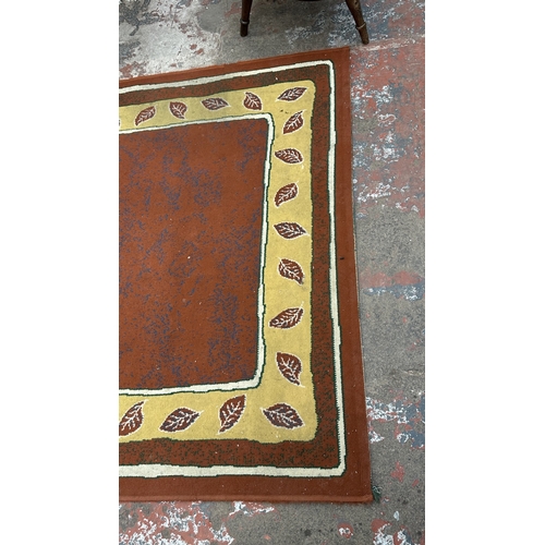 99 - A modern machine woven rug with leaf design - approx. 219cm x 161cm