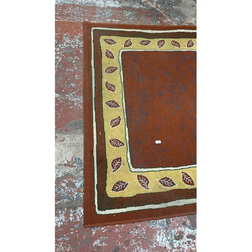 99 - A modern machine woven rug with leaf design - approx. 219cm x 161cm