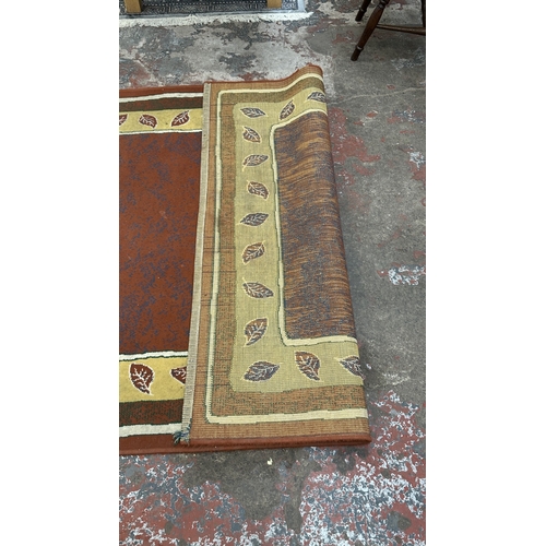 99 - A modern machine woven rug with leaf design - approx. 219cm x 161cm