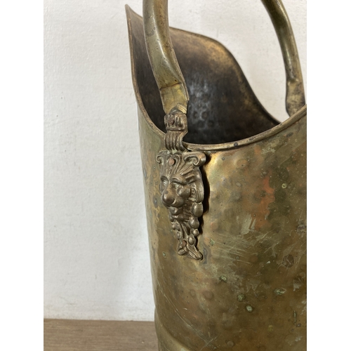 346 - A hammered brass coal scuttle with ceramic handle and three fireside accessories