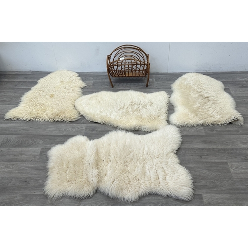 126 - Five items, one mid 20th century bamboo and rattan magazine rack and four sheepskin rugs, two Creati... 