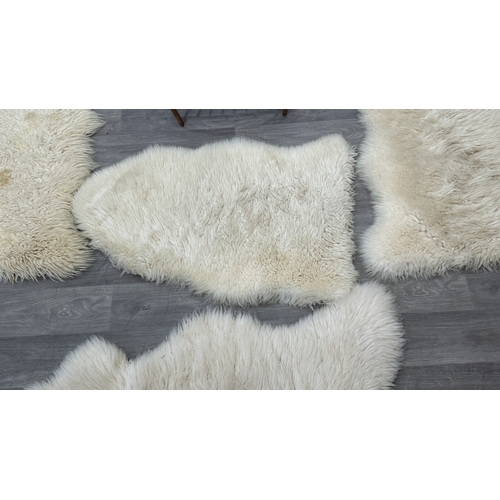 126 - Five items, one mid 20th century bamboo and rattan magazine rack and four sheepskin rugs, two Creati... 