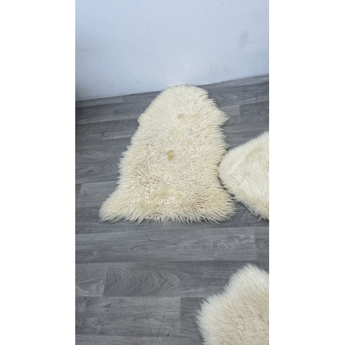 126 - Five items, one mid 20th century bamboo and rattan magazine rack and four sheepskin rugs, two Creati... 