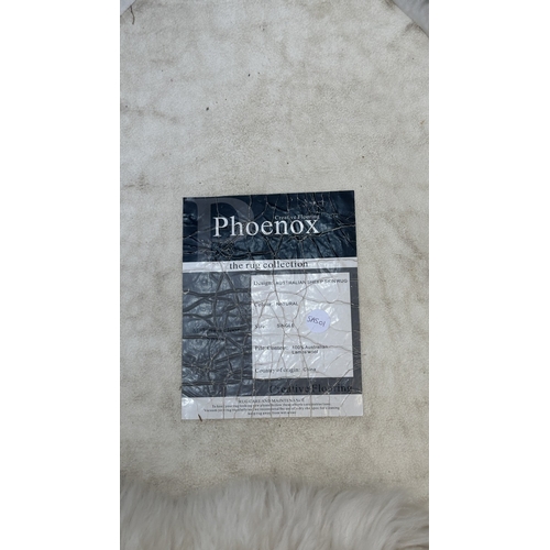 126 - Five items, one mid 20th century bamboo and rattan magazine rack and four sheepskin rugs, two Creati... 