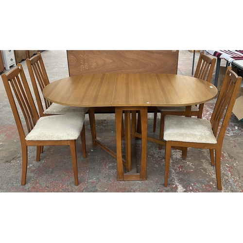 127 - A mid 20th century teak effect and beech drop leaf gate leg dining table and four fabric upholstered... 