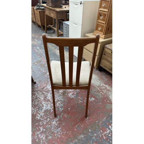 127 - A mid 20th century teak effect and beech drop leaf gate leg dining table and four fabric upholstered... 