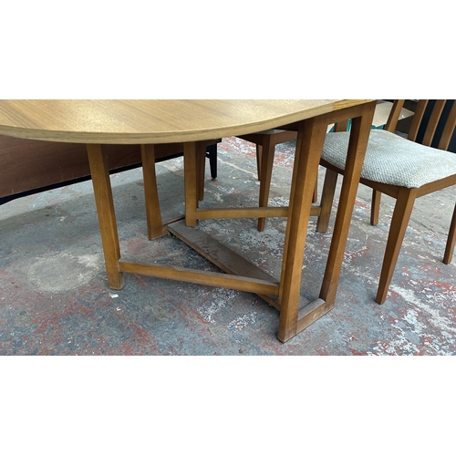 127 - A mid 20th century teak effect and beech drop leaf gate leg dining table and four fabric upholstered... 