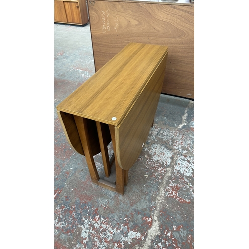 127 - A mid 20th century teak effect and beech drop leaf gate leg dining table and four fabric upholstered... 