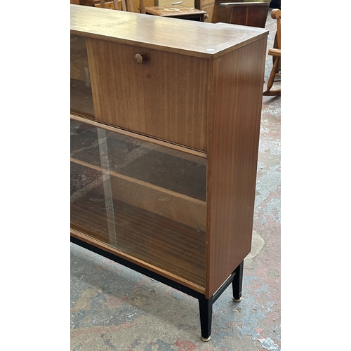129 - A mid 20th century Nathan teak and ebonised bookcase with four glass sliding doors - approx. 98cm hi... 