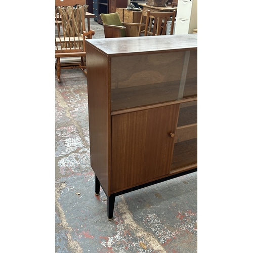 129 - A mid 20th century Nathan teak and ebonised bookcase with four glass sliding doors - approx. 98cm hi... 
