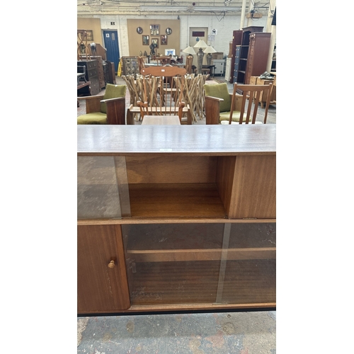 129 - A mid 20th century Nathan teak and ebonised bookcase with four glass sliding doors - approx. 98cm hi... 