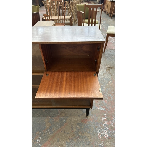129 - A mid 20th century Nathan teak and ebonised bookcase with four glass sliding doors - approx. 98cm hi... 