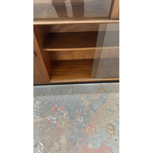 129 - A mid 20th century Nathan teak and ebonised bookcase with four glass sliding doors - approx. 98cm hi... 
