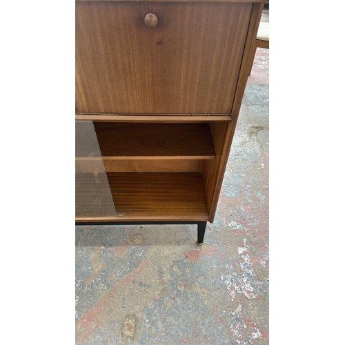 129 - A mid 20th century Nathan teak and ebonised bookcase with four glass sliding doors - approx. 98cm hi... 