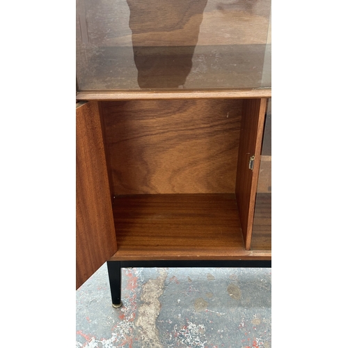 129 - A mid 20th century Nathan teak and ebonised bookcase with four glass sliding doors - approx. 98cm hi... 